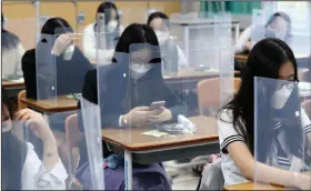  ?? (AP/Yohnap/Kim Jun-beom) ?? Seniors wait behind shielding for class to begin Wednesday at a high school in Daejeon, South Korea.