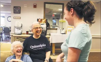  ??  ?? Cathleen Dacey, right, a Quinnipiac University law student, talks to Jeanne Piccirillo, 90, and Cairisse Miessau, 85, at Ashlar Village. Dacey will live at the center this school year as part of a learning program.