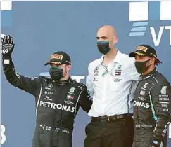  ??  ?? Die Mercedes-Piloten Valtteri Bottas (l.) und Lewis Hamilton (r.) feiern auf dem Podium mit dem luxemburgi­schen Ingenieur Dominique Riefstahl.