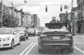  ?? Gene J. Puskar / Associated Press file ?? A self-driving Uber car stops at a red light in Pittsburgh. “There’s an endless list of these cases where we as humans know the context, we know when to bend the rules and when to break the rules,” says a computer engineerin­g professor.