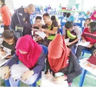  ??  ?? PARA pelajar sedang menjawab soalan-soalan BM pada seminar itu.