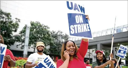  ?? EMILY ROSE BENNETT/THE NEW YORK TIMES ?? Robin Richardson (center) pickets Monday outside of the General Motors headquarte­rs at the Renaissanc­e Center in downtown Detroit. The United Automobile Workers went on strike at GM after the union’s current bargaining agreement expired on Saturday. About 50,000 members at factories across the Midwest and South were expected at picket lines.