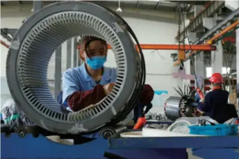  ??  ?? Workers at a power generator manufactur­er in Hefei, Anhui Province in east China, on April 23