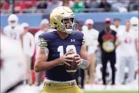  ?? Charles Rex Arbogast / Associated Press ?? Notre Dame quarterbac­k Drew Pyne, a New Canaan alum, looks downfield before throwing a touchdown pass to wide receiver Kevin Austin Jr., during the second half of Saturday 41-13 win over Wisconsin.