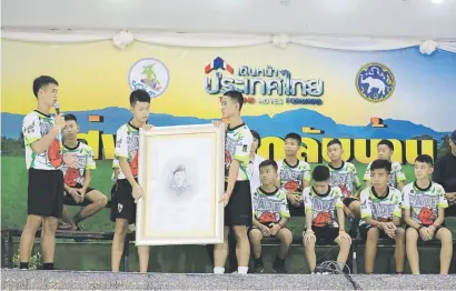  ?? Picture: Reuters ?? OUR HERO. Boys who were rescued from a flooded cave hold a portrait of the former Navy Seal diver Saman Kunan, who died during the rescue operation, as they pay their respects during a news conference in the northern province of Chiang Rai, Thailand, yesterday.