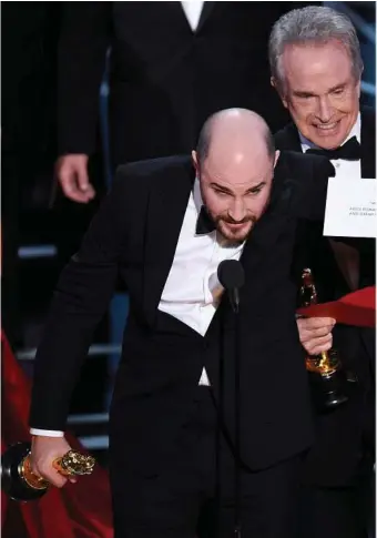  ??  ?? Jordan Horowitz, producer of “La La Land,” left, shows the envelope revealing “Moonlight” as the true winner of best picture at the Oscars as Warren Beatty and host Jimmy Kimmel, right, look on. The film academy and its accounting firm, PwC, announced...