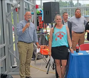  ?? All photos by TONY LENAHAN/THE Saline Courier ?? Bryant Mayor Allen Scott, left, speaks to the crowd serving as a witness at the World’s Largest Swimming Lesson Thursday at Bryant Aquatics Center at Bishop Park. Event organizer and Bryant Aquatics Director Kristin Robinson stands beside him.