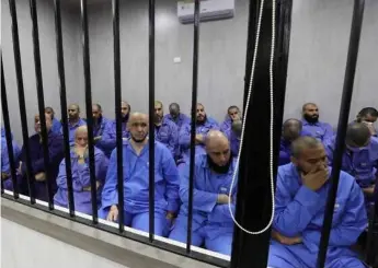  ?? AFP/VNA Photo ?? Jihadists accused of being members of the Islamic State (IS) group sit in the defendant booth during their trial, in the northweste­rn Libyan city of Misrata Monday.