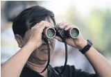  ??  ?? ALL EYES: A punter uses binoculars to watch a horse race at a racecourse in Bangkok.