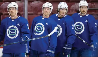  ?? The Canadian Press ?? Vancouver Canucks Daniel Sedin, left, Henrik Sedin, Loui Eriksson and Alexander Edler, all of Sweden, line up for a drill during the NHL hockey team’s training camp, in Vancouver.