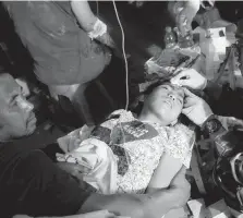  ??  ?? An army doctor examines an injured child outside an army hospital.