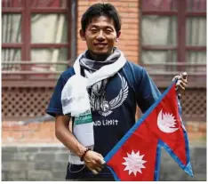  ?? — AP ?? Into thin air: Kuriki with a Nepalese flag before his eighth attempt to scale Mount Everest in Kathmandu.