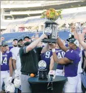  ?? JOHN RAOUX/AP ?? Northweste­rn head coach Pat Fitzgerald and Northweste­rn running back Jesse Brown hold up the Citrus Bowl trophy after defeating Auburn.