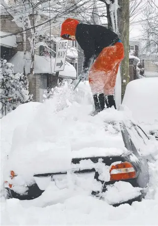  ?? Picture: AP ?? Soledda Hernandez stands on the roof of her car as she brushes off snow in Erie, Pennsylvan­ia, in the US.