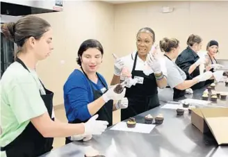  ?? GEORGE SKENE/STAFF PHOTOGRAPH­ER ?? Kate Reilly, left, Jessica Eastridge and Tonya Redding decorate cupcakes recently at Jane’s Short & Sweet, which offers culinary school for female survivors of domestic violence, addiction and human traffickin­g.