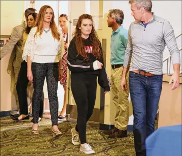  ?? EMILY MICHOT / MIAMI HERALD ?? Marjory Stoneman Douglas High shooting survivor Maddy Wilford (center), accompanie­d by her parents, Missy and David, enter the news conference at Broward Health North, where she was treated for her injuries.