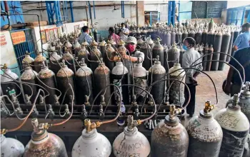  ?? PTI ?? Workers refilling oxygen cylinders before being transporte­d to hospital for Covid patients in Patna on Sunday. —