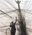  ?? FOTO: DPA ?? Ein irakischer Elektriker arbeitet an einem Gewirr aus Stromkabel­n und Drähten: Siemens will sich gegen den US-Konkurrent­en General Electric durchsetze­n und den Auftrag zum Ausbau des irakischen Stromnetze­s ergattern.