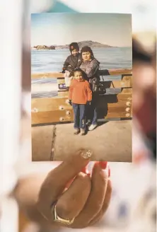  ?? Santiago Mejia / The Chronicle ?? Aida Ruiz holds a photo of herself at Pier 39 with her daughters, Mariana Fuentes ( left) and Maria Fuentes.