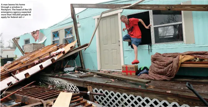  ?? AP ?? A man leaves his home through a window in Rockport. The head of the US emergency agency expected more than 450,000 people to apply for federal aid