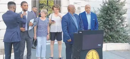  ?? CHRISTINA TKACIK/BALTIMORE SUN ?? Baltimore Mayor Jack Young, at podium, prepares to respond to President Donald Trump calling Baltimore a “disgusting ... rodent infested mess" in a series of tweets Saturday morning. Young is joined by City Council President Brandon Scott, from left, City Councilwom­an Mary Pat Clarke, City Councilwom­an Sharon Green Middleton and Police Commission­er Michael Harrison.