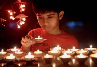  ?? Photo by Kiran Prasad ?? A boy lights earthen lamps as part of Diwali celebratio­ns in Dubai on Wednesday. —