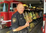  ?? DAVID S. GLASIER — THE NEWS-HERALD ?? Hambden Township Volunteer Fire Department Chief Scott A. Hildenbran­d, next to an engine truck at the station on Old State Road