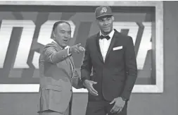  ?? GETTY IMAGES ?? Elie Okobo poses with NBA Deputy Commission­er Mark Tatum after being drafted 31st overall by the Suns.