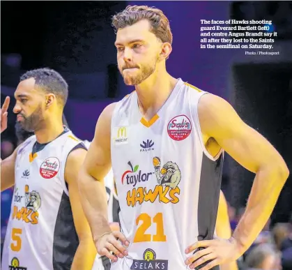  ?? Photo / Photosport ?? The faces of Hawks shooting guard Everard Bartlett (left) and centre Angus Brandt say it all after they lost to the Saints in the semifinal on Saturday.