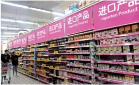  ??  ?? Customers look at imported goods in a supermarke­t in Shanghai on October 29, 2018