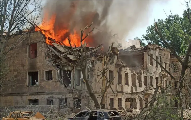  ?? AFP ?? La clínica atacada por misiles rusos era un centro de atención psiquiátri­ca en Dnipró. Quedó destrozada y ayer mostraba extensas columnas de fuego y humo.