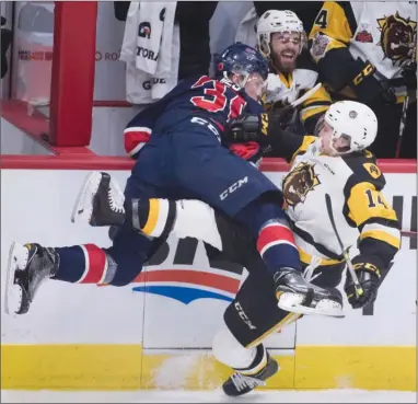  ?? The Canadian Press ?? Regina Pats forward Robbie Holmes, left, collides with Hamilton Bulldogs forward Will Bitten during the first period of their Memorial Cup semifinal on Friday in Regina. The Pats won 4-2.