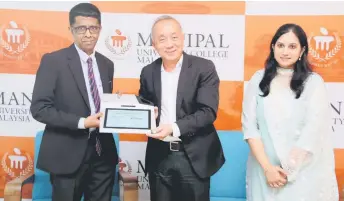  ?? ?? (From left) Srikanth and Kee show the digital agreement after the signing ceremony, as MUCM director of examinatio­n Prof Dr Sowmya Nettem looks on.