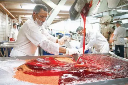  ?? Houston Chronicle via AP ?? A candy maker works to mix ingredient­s together at the Atkinson Candy Company on May 17 in Lufkin, Texas.