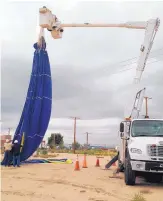  ?? RICK NATHANSON/JOURNAL ?? A hot air balloon envelope is removed from electrical power lines by PNM crews Wednesday during a demonstrat­ion on balloon safety.