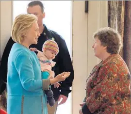  ?? Don Emmert
AFP/Getty Images ?? HILLARY RODHAM CLINTON holds Molly Morse as she talks to Marsha Dubois, owner of Kristin’s Bistro & Bakery, during a campaign stop in Keene, N.H.