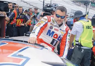  ?? MICHAEL CONROY/ASSOCIATED PRESS ?? Tony Stewart climbs into his car Saturday for qualifying for today’ Brickyard 400 at Indianapol­is Motor Speedway. It will be his last race at the track since he is retiring at the end of the season.