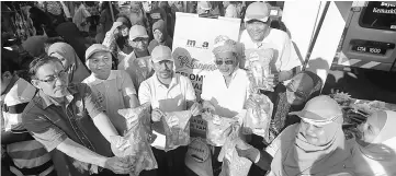  ??  ?? Shafik (third left), Mohd Sallehhudd­in (fourth left) and others show Q’Fish products at the UTC Pahang. — Bernama photo