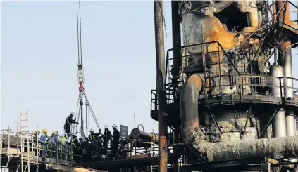  ?? PHOTO: REUTERS ?? Workers repair the Saudi Aramco oil facility in Abqaiq after it was damaged in a drone attack earlier this month.