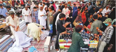  ?? Reuters ?? People shopping from stalls ahead of the Eid Al Fitr after the government eased lockdown restrictio­ns, in Karachi, on May 21.