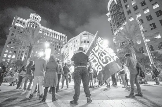  ?? WILLIE J. ALLEN JR./ORLANDO SENTINEL ?? Demonstrat­ors honor George Floyd during a vigil outside Orlando City Hall on April 20. Former police Officer Derek Chauvin was found guilty during the Minneapoli­s trial.