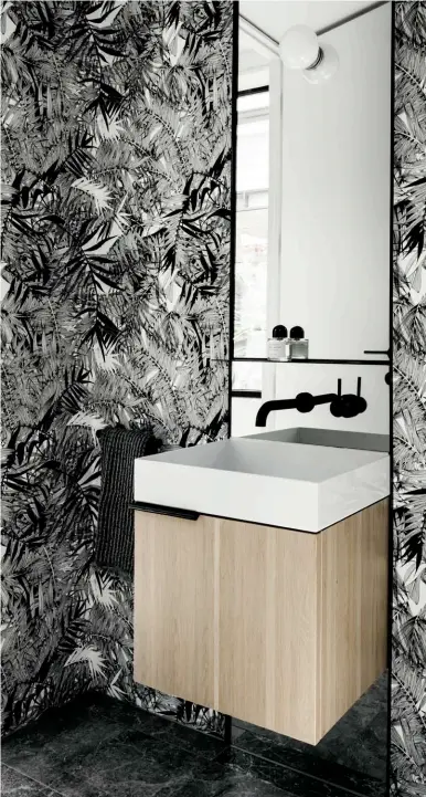  ??  ?? ELEMENT OF SURPRISE The powder room makes a graphic statement with wallpaper from Designers Guild that complement­s the black tapware and accessorie­s. 驚喜所在 化妝間以Design­ers Guild牆紙裝飾，氣氛獨特，並配襯黑色龍頭和裝飾­品。