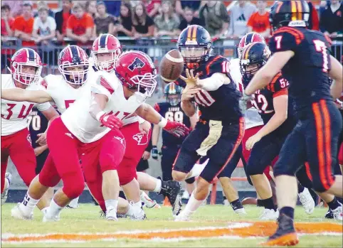  ?? Westside Eagle Observer/RANDY MOLL ?? MARK HUMPHREY mhumphrey@nwadg.com With Farmington senior Josh Stettmeier closing in for the tackle, Gravette quarterbac­k Cy Hilger pushes the ball off to Gravette runningbac­k Chace Austin during play between Gravette and Farmington in Lion Stadium on Friday.