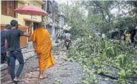  ?? BIKAS DAS THE ASSOCIATED PRESS ?? A Buddhist monk walks through a road laid with fallen trees and branches after cyclone Amphan hit Kolkata, India, on Thursday.