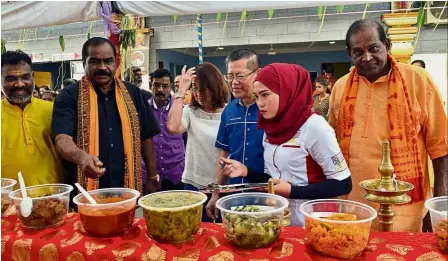  ??  ?? Healthy and delicious: Soorian (in black shirt) showing ‘Malaysia Book of Records’ senior research journalist Nurasyikin Ramli (in headscarf) some of the dishes as Khoo (in blue shirt) looks on during the event in Taman Desa Tebrau, Johor Baru.