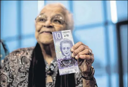  ?? CP PHOTO ?? Wanda Robson, sister of Viola Desmond, holds the new $10 bank note featuring Desmond during a press conference in Halifax on Thursday. Desmond is the first Canadian woman to be featured on a regularly circulatin­g bank note.