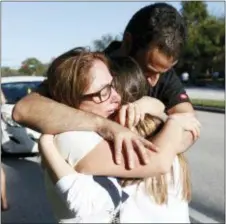  ?? ASSOCIATED PRESS ?? Family members are reunited with students outside Marjory Stoneman Douglas High School on Feb. 14 in Parkland, Fla. The shooting at a South Florida high school sent students rushing into the streets as SWAT team members swarmed in and locked down the...