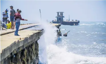  ?? JOSEFINA VILLARREAL ?? Una fuerte ola impacta en el muelle de Puerto Colombia ante la mirada de un visitante.