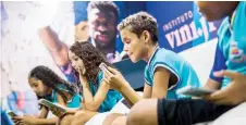  ?? — AFP photo ?? School children use the Vini Jr Institute educationa­l app on mobile phones at the Visconde de Sepetiba municipal school.