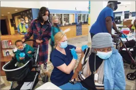  ?? Christian Abraham / Hearst Connecticu­t Media ?? Norwalk Hospital nurse Mallory Bates administer­s a COVID-19 vaccine to Elizabeth Jackson at Brien McMahon High School in Norwalk on March 20.